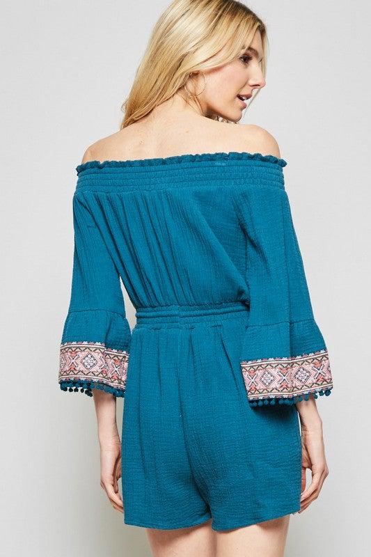 This romper features cotton fabrication with off the shoulder bodice. Elastic on the waist, bell sleeves with pom pom details. We love the embroidery design on this! Fully lined, easy fit